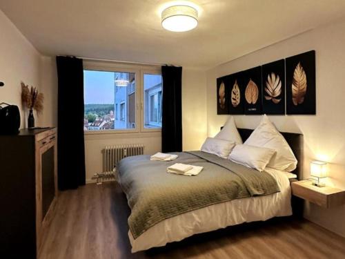 a bedroom with a bed and a large window at Stylish Apartment Balcony 2 BR Central in Kaiserslautern