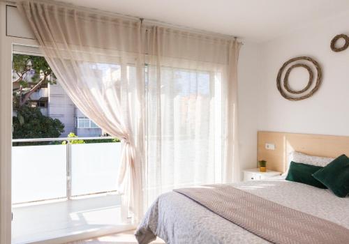 a bedroom with a bed and a large window at Villa Paula Trinidad in Salou