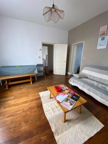 a living room with a bed and a table at Logement proche centre-ville in Bourges