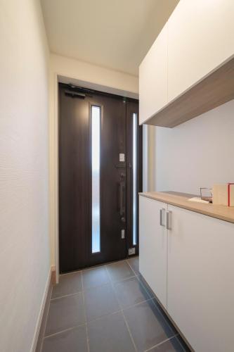 a kitchen with a black door and a tile floor at the UNIT5 HOUSE Roppongi in Tokyo