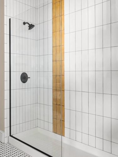 a bathroom with a shower with white tiles at The Courier Hotel in Salem