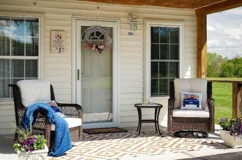two wicker chairs and a table on a porch at Center Hill Cottage in Smithville