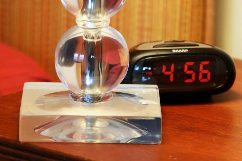 an alarm clock and a clock with a wine glass on a table at Breezy Hill Inn in Fleischmanns