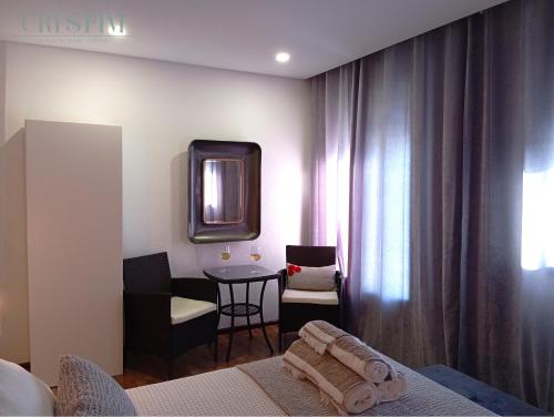 a room with a bed and a table and a mirror at Casa Crespim in Monção