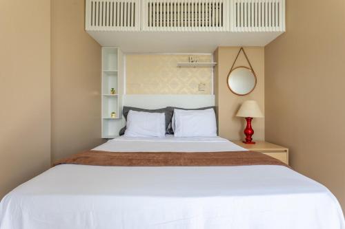 a bedroom with a large white bed and a mirror at Studio completo estilo casa com lava e seca, Go Inn in Brasília