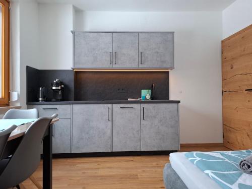 a kitchen with stainless steel cabinets and a table at FEWO Erika in Presseggen
