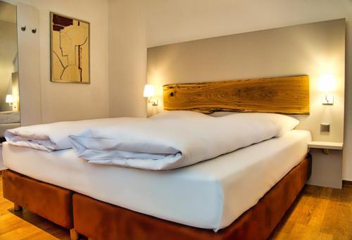 a large white bed in a hotel room at Parkhotel Steimker Berg Wolfsburg in Wolfsburg