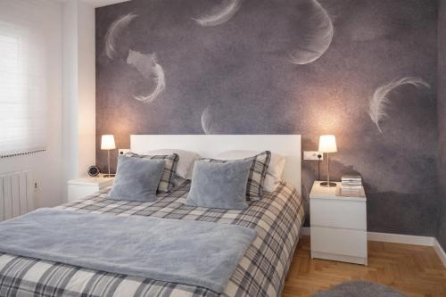a bedroom with a bed with a painting on the wall at La Bahía in Baiona