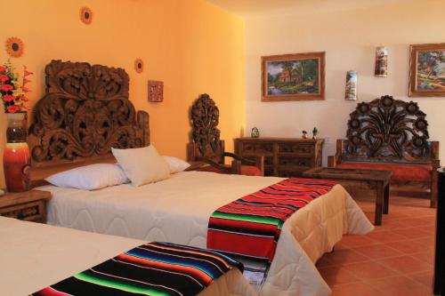a bedroom with two beds and a chair at Cielito Lindo in Los Algodones