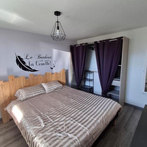 a bedroom with a large bed with purple curtains at maison de vacances gite duplex in Erquy