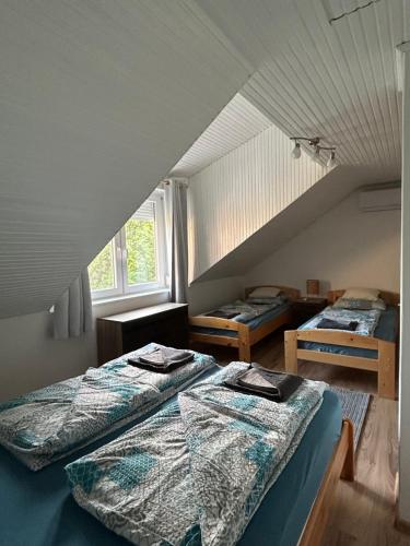 two beds in a room with an attic at ReZa111 in Békésszentandrás