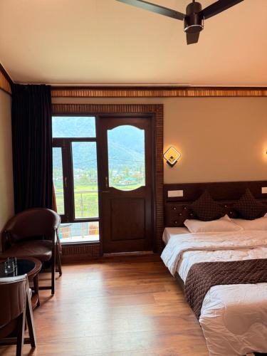 a hotel room with a bed and a large window at Haari Wann in Srinagar