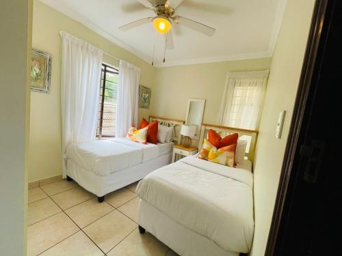 a bedroom with two beds and a ceiling fan at 15 Surabaya in Margate