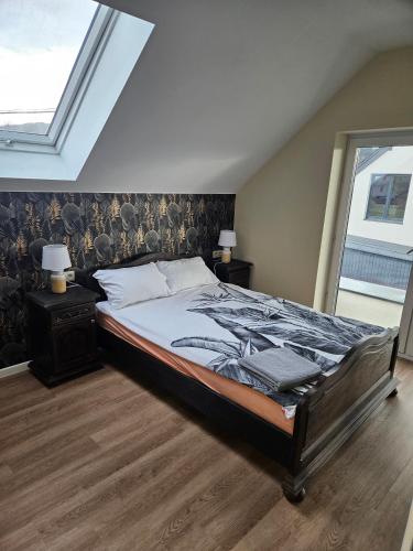 a bedroom with a large bed and a window at Harmonia in Radochów