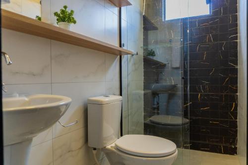 a bathroom with a toilet and a sink and a shower at Bananeiras Solar in Bananeiras