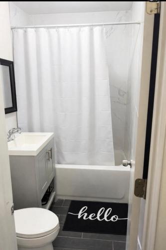 a bathroom with a white shower curtain and a toilet at Anne room A in Irvington