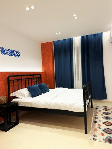 a bedroom with a bed with blue pillows on it at DuoNest-BoHo Sunset in Tirana