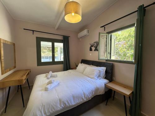 a bedroom with a bed with two towels on it at Pine and Sea in Artemida