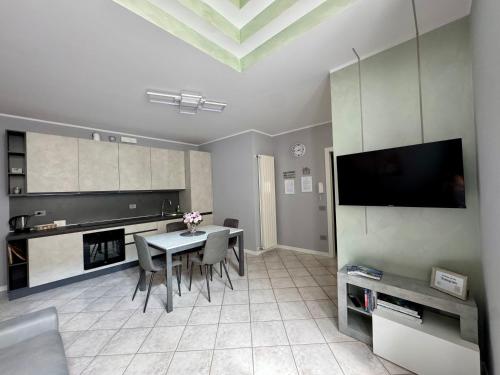 a living room with a table with chairs and a tv at Le Scuderie - casa vacanze in Intra
