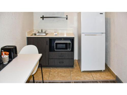 a small kitchen with a refrigerator and a sink at Studio 6-Grand Prairie, TX in Grand Prairie