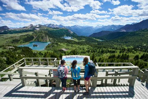 a group of children standing on top of a viewing platform at Sunshine Mountain Lodge in Banff