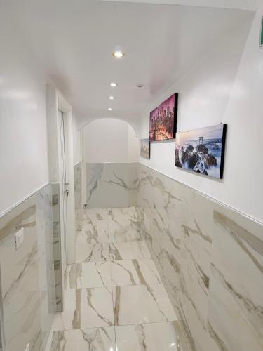 a bathroom with marble floors and paintings on the wall at Hotel Eurorooms in Rome