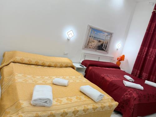 a bedroom with two beds with towels on them at Hotel Eurorooms in Rome