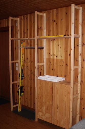 a wooden wall with a shelf and a skis at Comfortable and cozy cottage in Sysslebäck