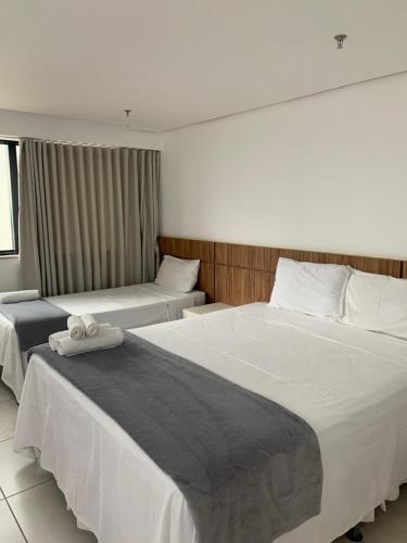 a hotel room with two beds with white sheets at Prime Flats in Palmas