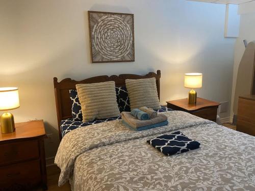 a bedroom with a bed with two lamps on it at Luxury comforts getaway home in Brossard