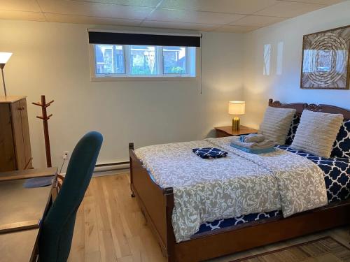 a bedroom with a bed and a window and a chair at Luxury comforts getaway home in Brossard