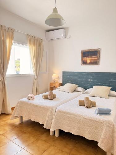 two beds in a white room with a window at Apartamentos La Fragata in Es Arenals