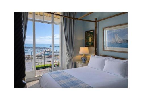 a bedroom with a bed and a large window at The Royal Harbour Hotel in Ramsgate