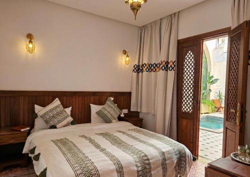 a bedroom with a bed and a sliding glass door at Riad Jô & Spa in Marrakesh