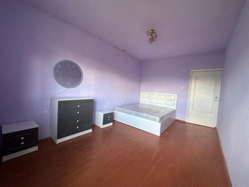 a bedroom with purple walls and a bed and a mirror at 2 Floor House with big garden and Mountain View in Bjni in Bjni
