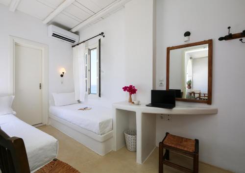 a white room with a desk and a mirror at Panorama Hotel in Naxos Chora
