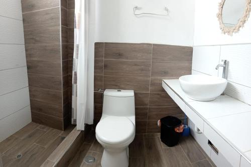 a bathroom with a white toilet and a sink at VistamarGrau in Caleta Grau