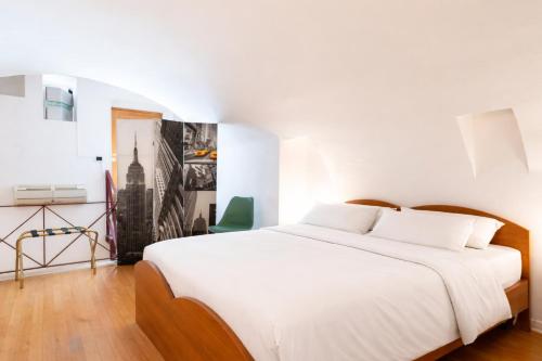a bedroom with a white bed and a green chair at Palazzo Barone in Bari