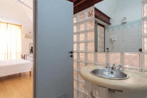 a bathroom with a sink and a room with a bed at Palazzo Barone in Bari
