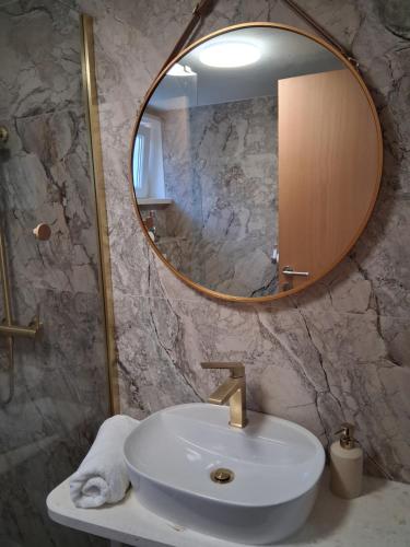 a bathroom with a sink and a mirror at Apartman Golden Stone in Ivanica