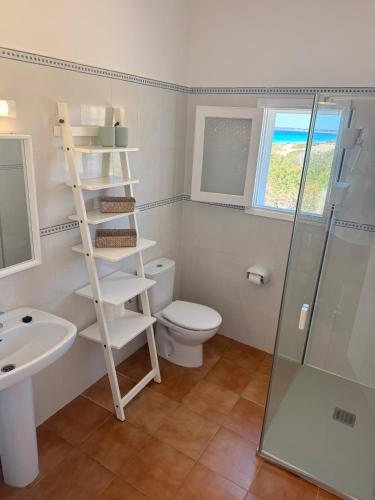 a bathroom with a toilet and a sink and a shower at Apartamentos La Fragata in Es Arenals