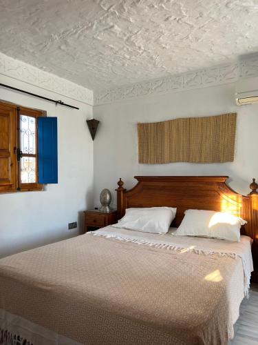 a bedroom with a large bed with white sheets at Houch Ennejma, Chambres d'hotes, Spa et bien être in Al Ḩārah al Kabīrah