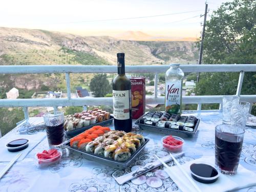 a table with two trays of food and a bottle of wine at 2 Floor House with big garden and Mountain View in Bjni in Bjni
