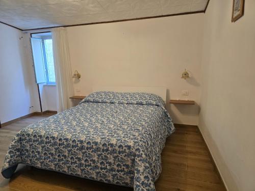 a bedroom with a bed with a blue and white comforter at Borgo Cipampini in Petralia Soprana