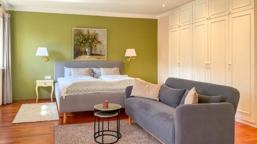 a living room with a bed and a couch at Kaiser's Landhaus in Schliersee