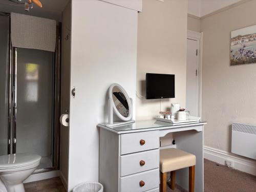 a white bathroom with a sink and a mirror at The Wentworth at Goodrington Sands in Paignton