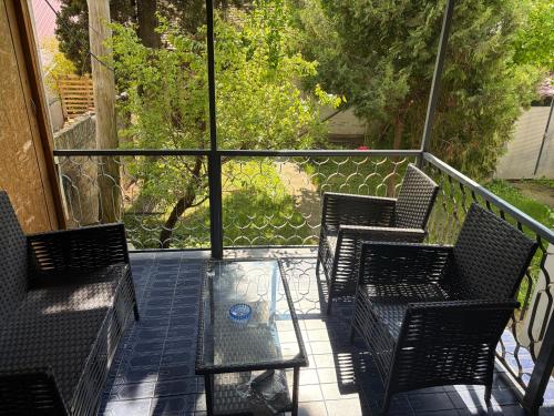 a balcony with three chairs and a glass table at Comfy Attic in Pančevo