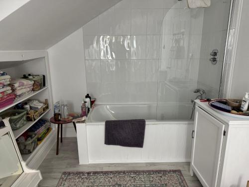 a white bathroom with a tub and a sink at 64 Cressingham Road in London