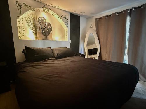 a bedroom with a large bed with a large window at Jacuzzi privatif Appartement premium Vendôme in Vendôme