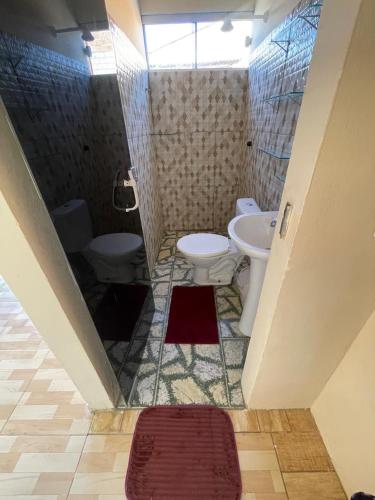 a bathroom with two toilets and a sink and a shower at Pousada Fonseca in Salinópolis